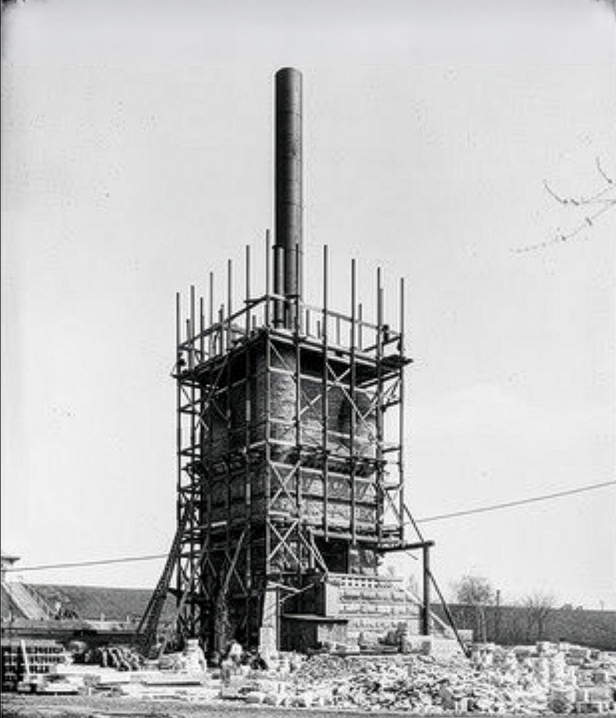 The standpipe rising inside early scaffolding, 1897